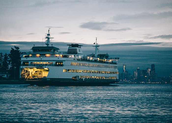 Large ferry boat cruises toward downtown Seattle.